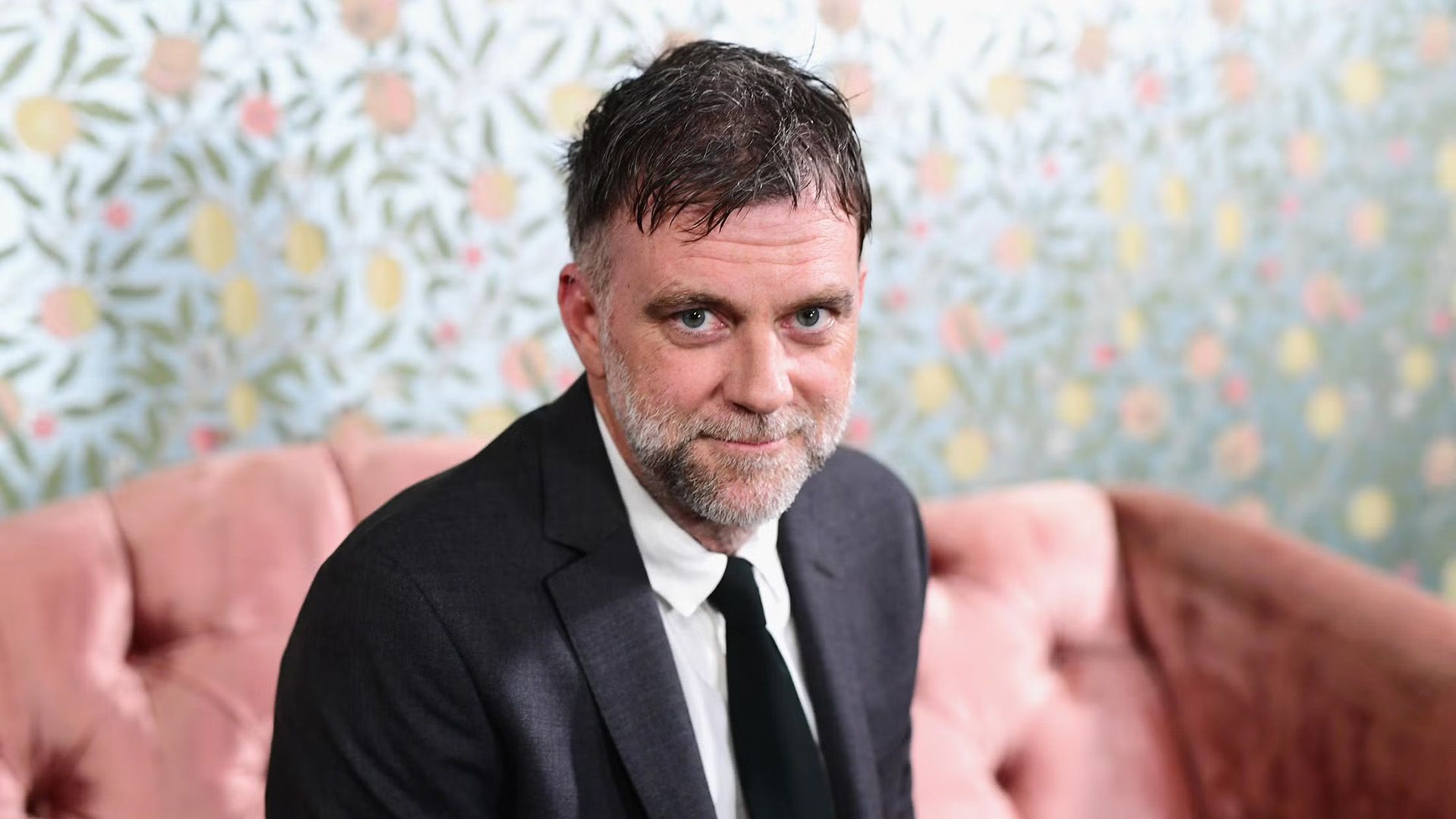 Il regista Paul Thomas Anderson seduto su un divano rosa