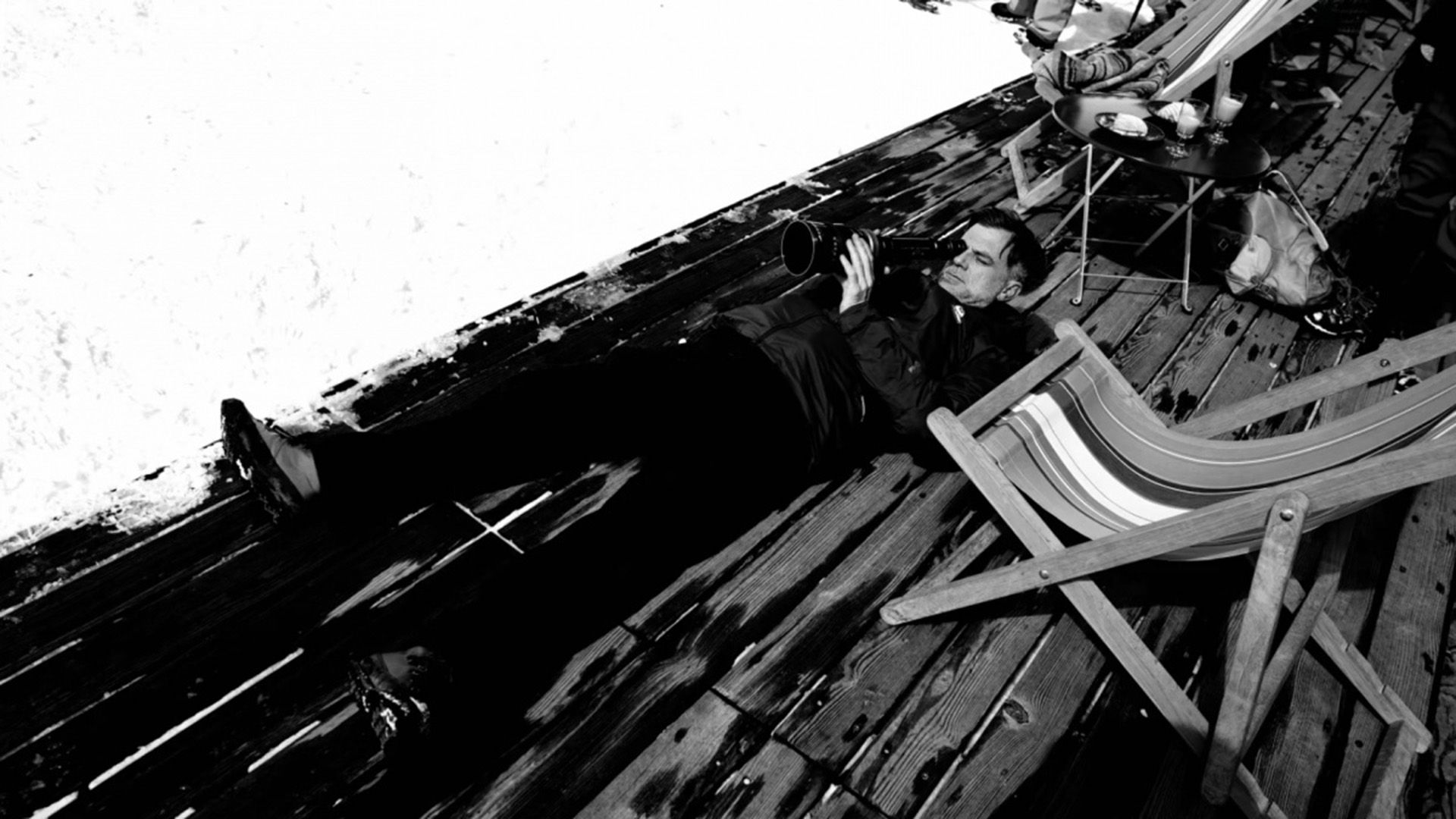 Paul Thomas Anderson sdraiato sul pavimento mentre guarda nell'obiettivo della macchina da presa