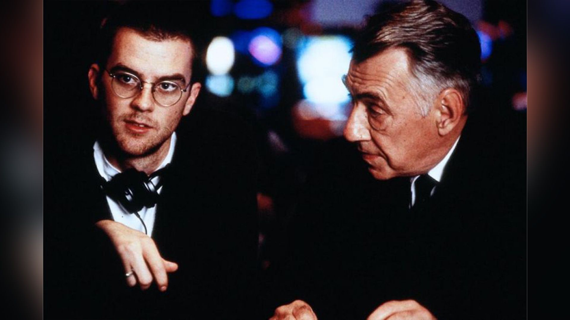 Paul Thomas Anderson con gli occhiali e le cuffie al collo e Philip Baker Hall