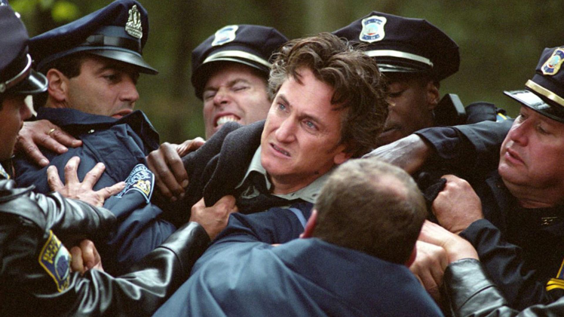 Un Sean Penn furioso trattenuto da cinque poliziotti in uniforme