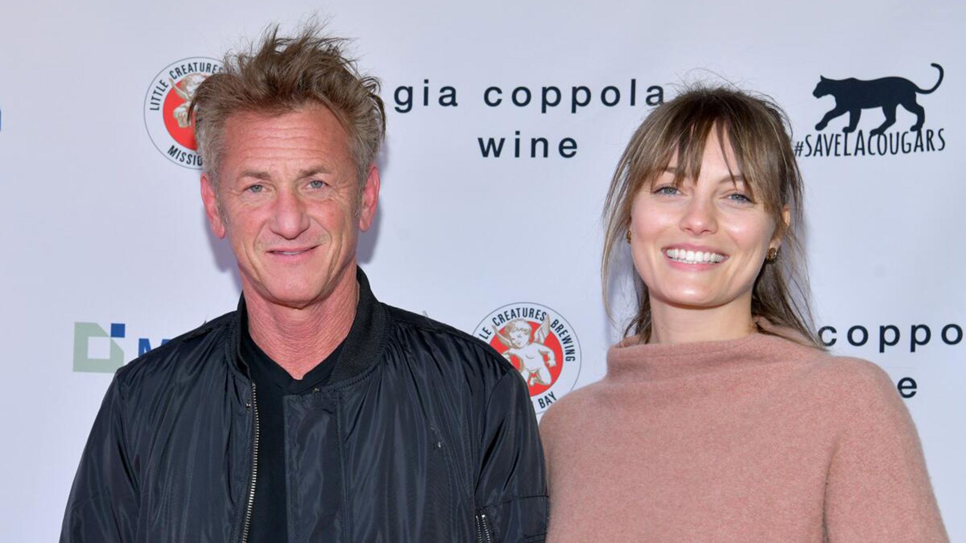 Sean Penn con una giacca nera e Leila George con un maglione beige