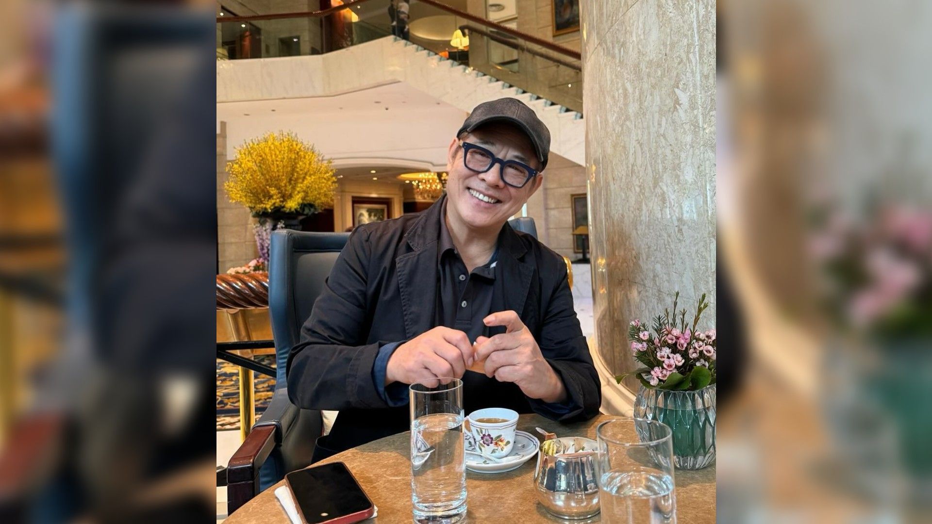 Jet Li con cappello e occhiali da sole mentre pranza in un ristorante