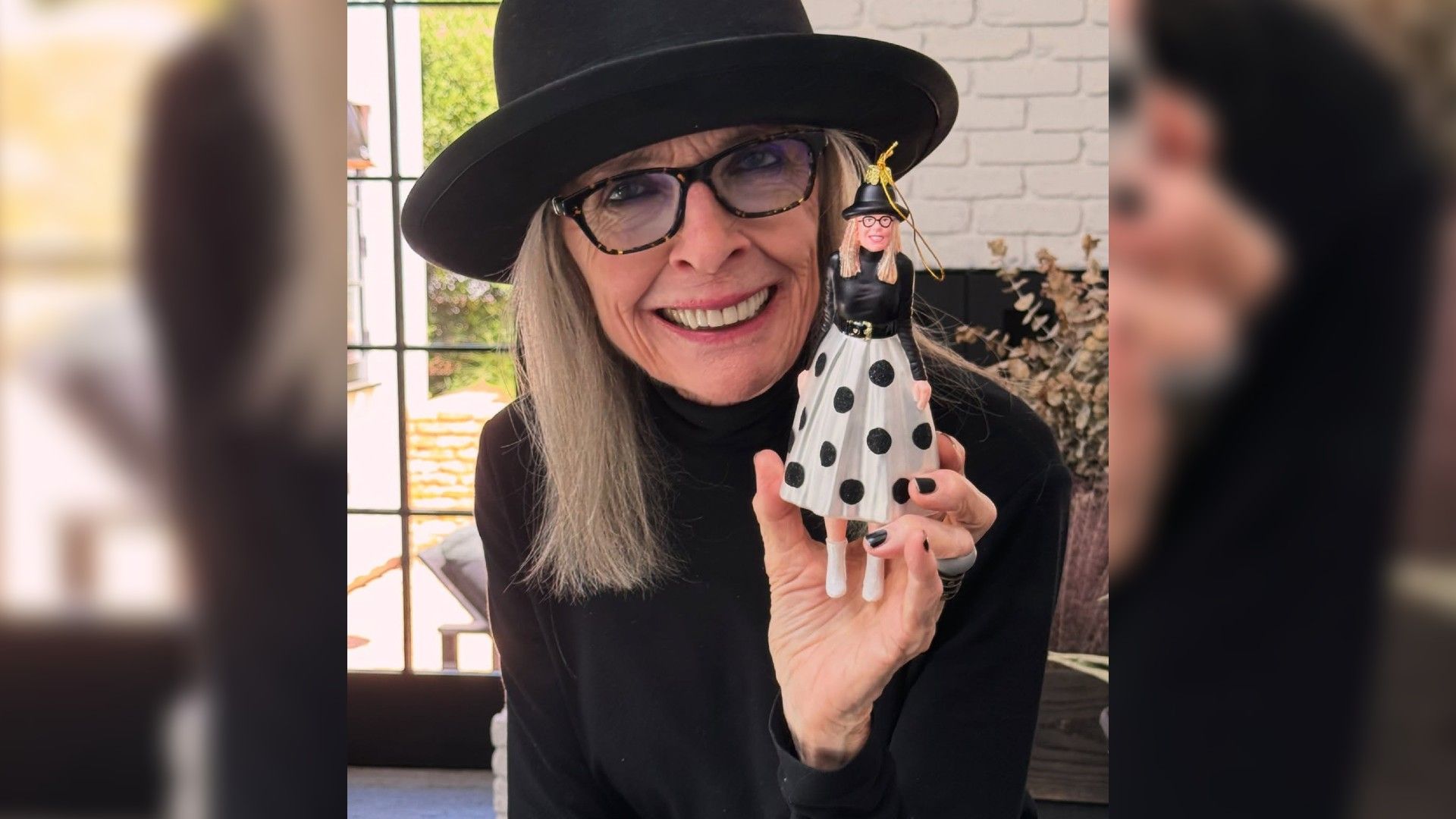 Diane Keaton con cappello mostra un ornamento natalizio che è la sua replica esatta
