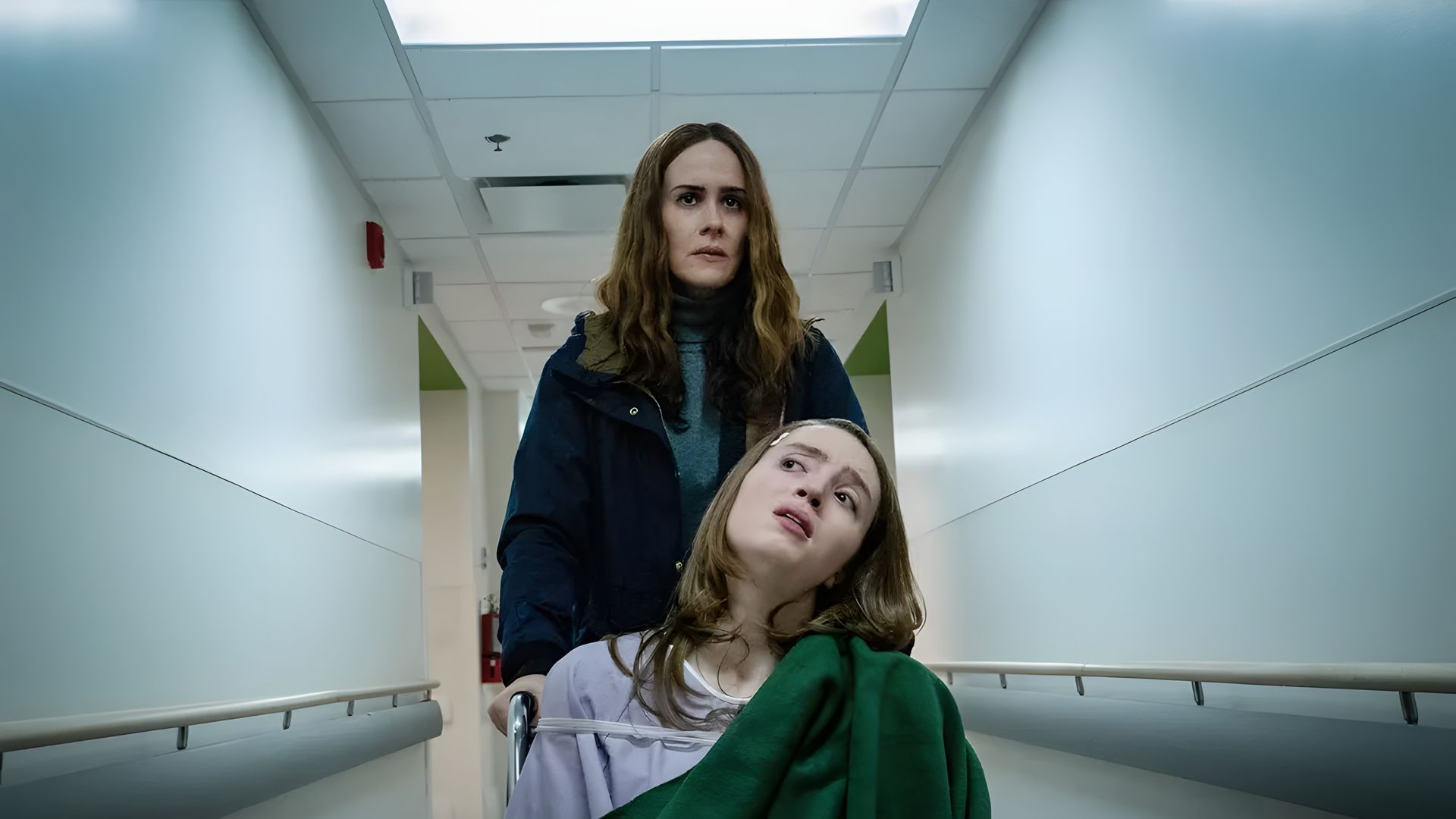 Jennifer Connelly spinge Alice Englert su una barella, scena dal film Bad Behaviour
