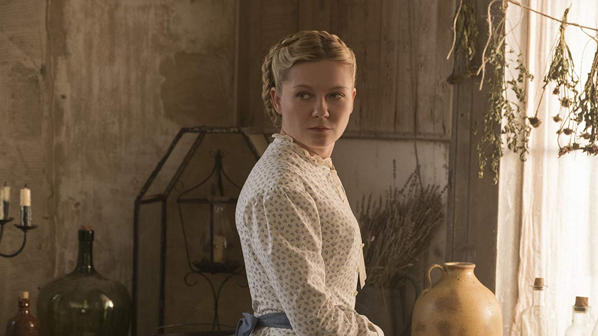 Kirsten Dunst in un abito bianco vintage in posa di tre quarti