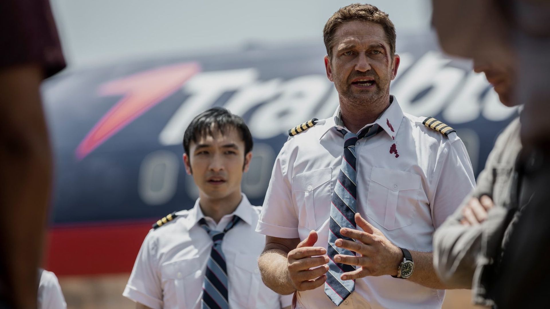 Gerard Butler in uniforme da pilota sullo sfondo di un aereo, scena del film