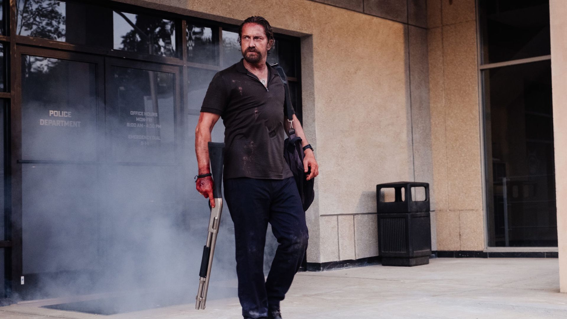 Gerard Butler in piedi con un'arma in mano, scena del film