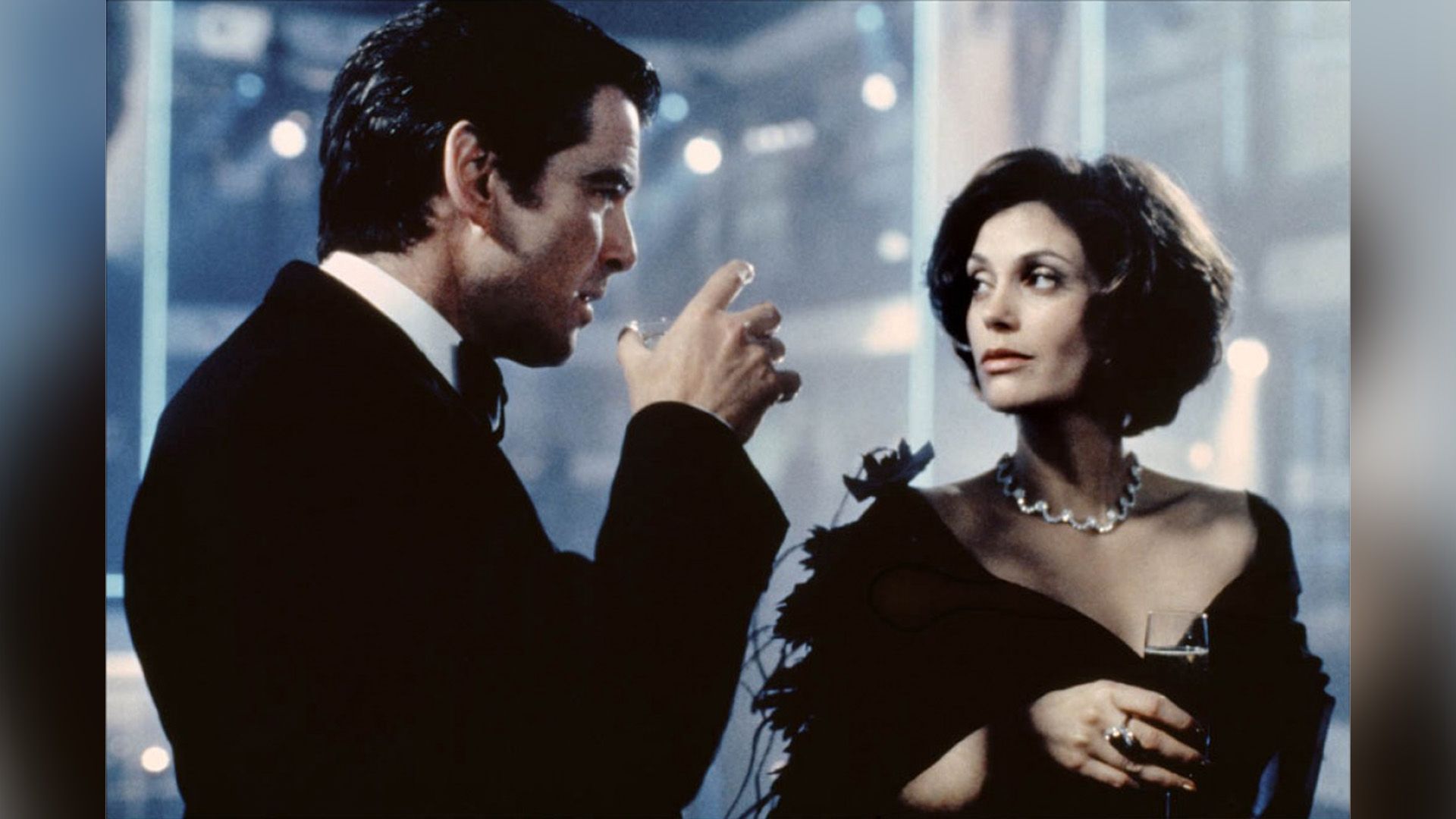 Teri Hatcher in abito da sera e collana di diamanti tiene un bicchiere con un uomo in smoking accanto a lei