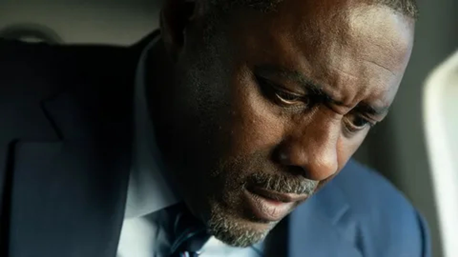 Idris Elba in giacca e cravatta, primo piano del viso