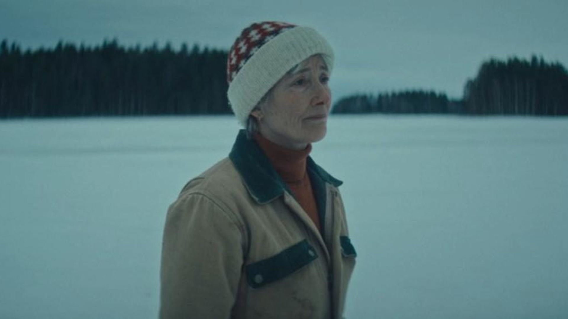 Emma Thompson in abiti invernali su uno sfondo innevato, foto con tonalità blu