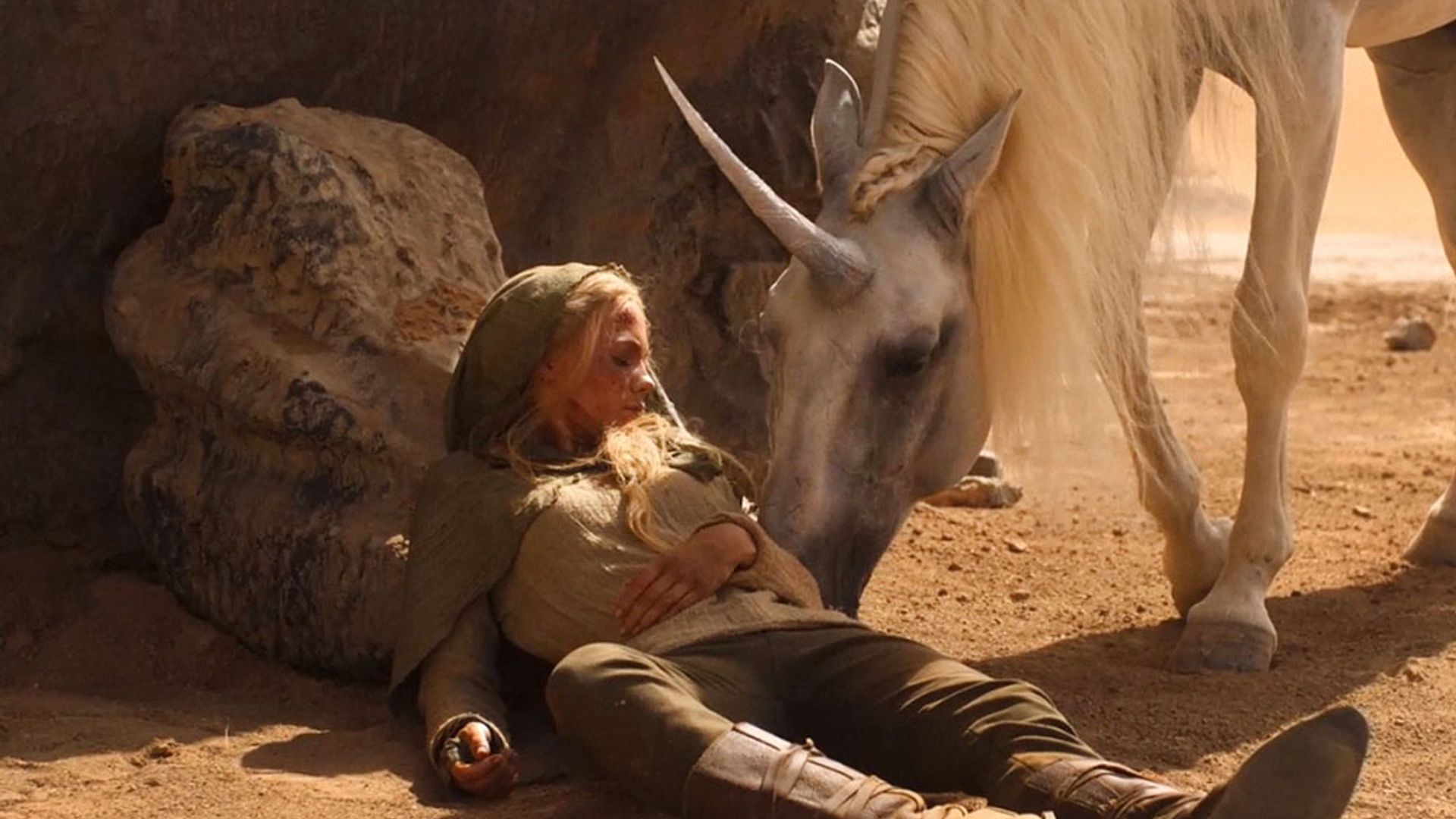 Freya Allan accarezza un cavallo con un corno, scena dalla serie The Witcher