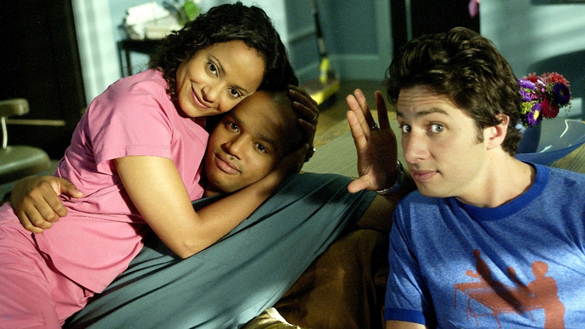 Judy Reyes abbraccia Donald Faison con Zach Braff seduto nelle vicinanze