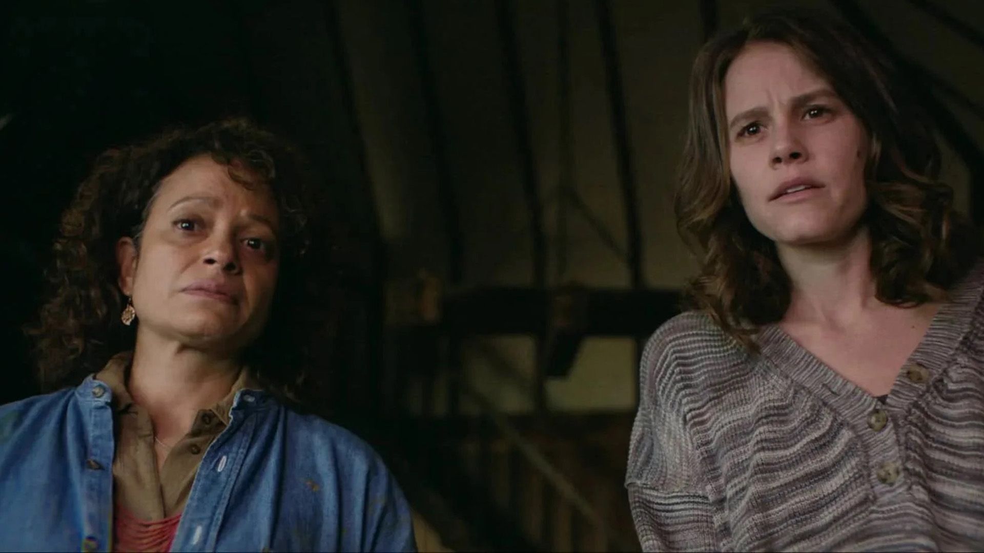 Judy Reyes in giacca di jeans guarda in basso preoccupata, una giovane donna in piedi accanto a lei