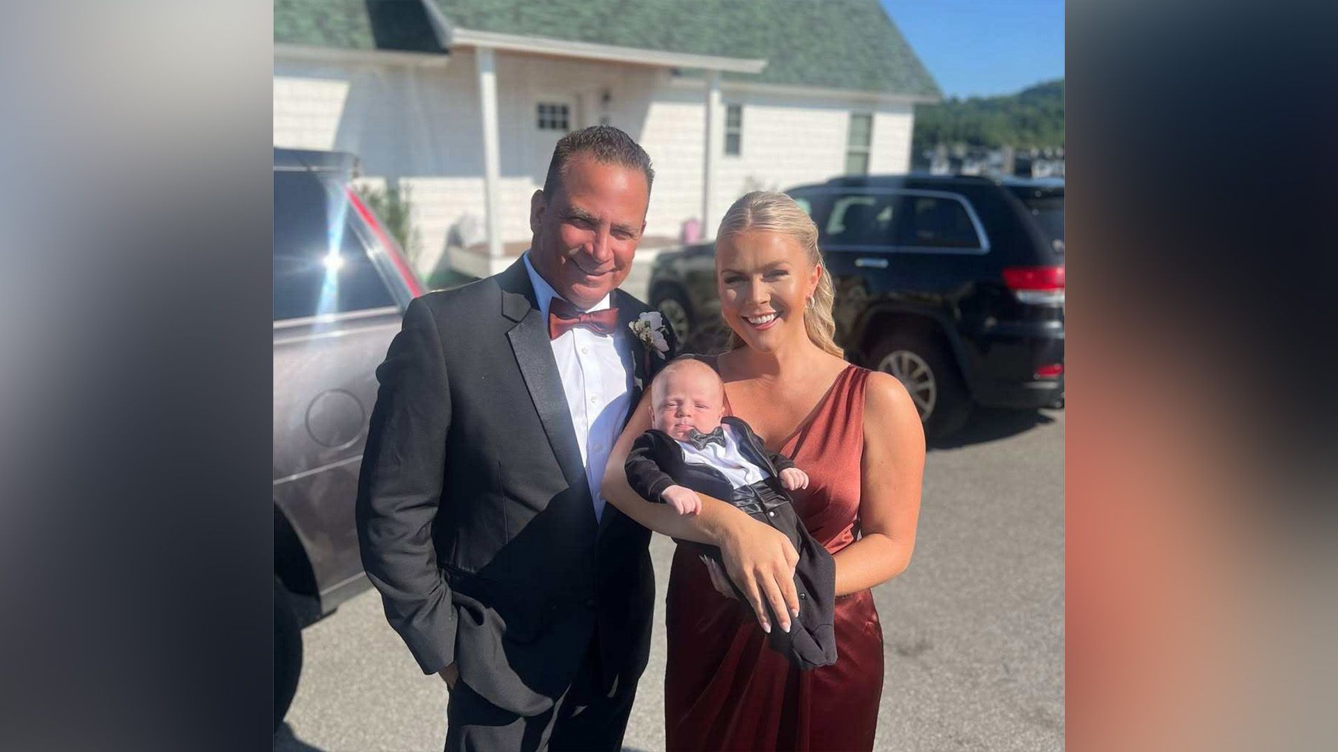 Un uomo in frac e una donna in abito elegante con un bambino in braccio