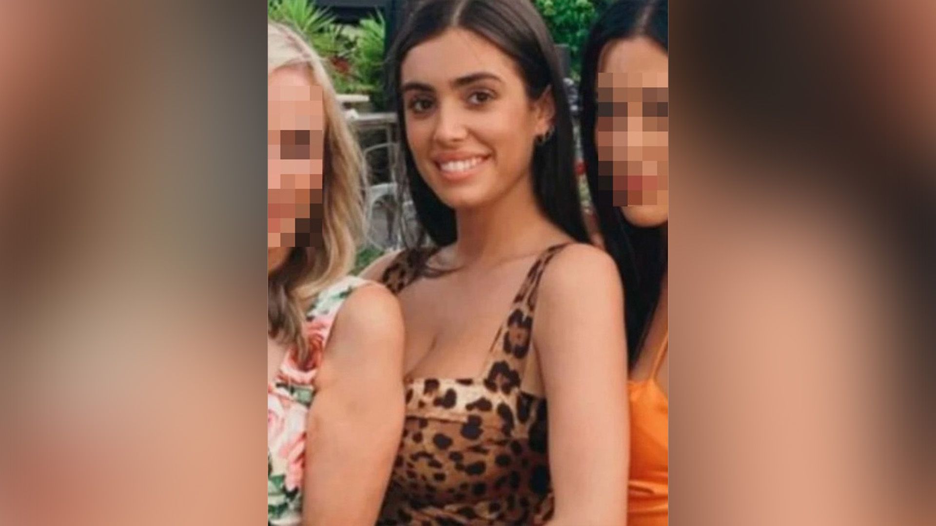 Una ragazza sorridente con capelli lunghi in un vestito a stampa leopardata
