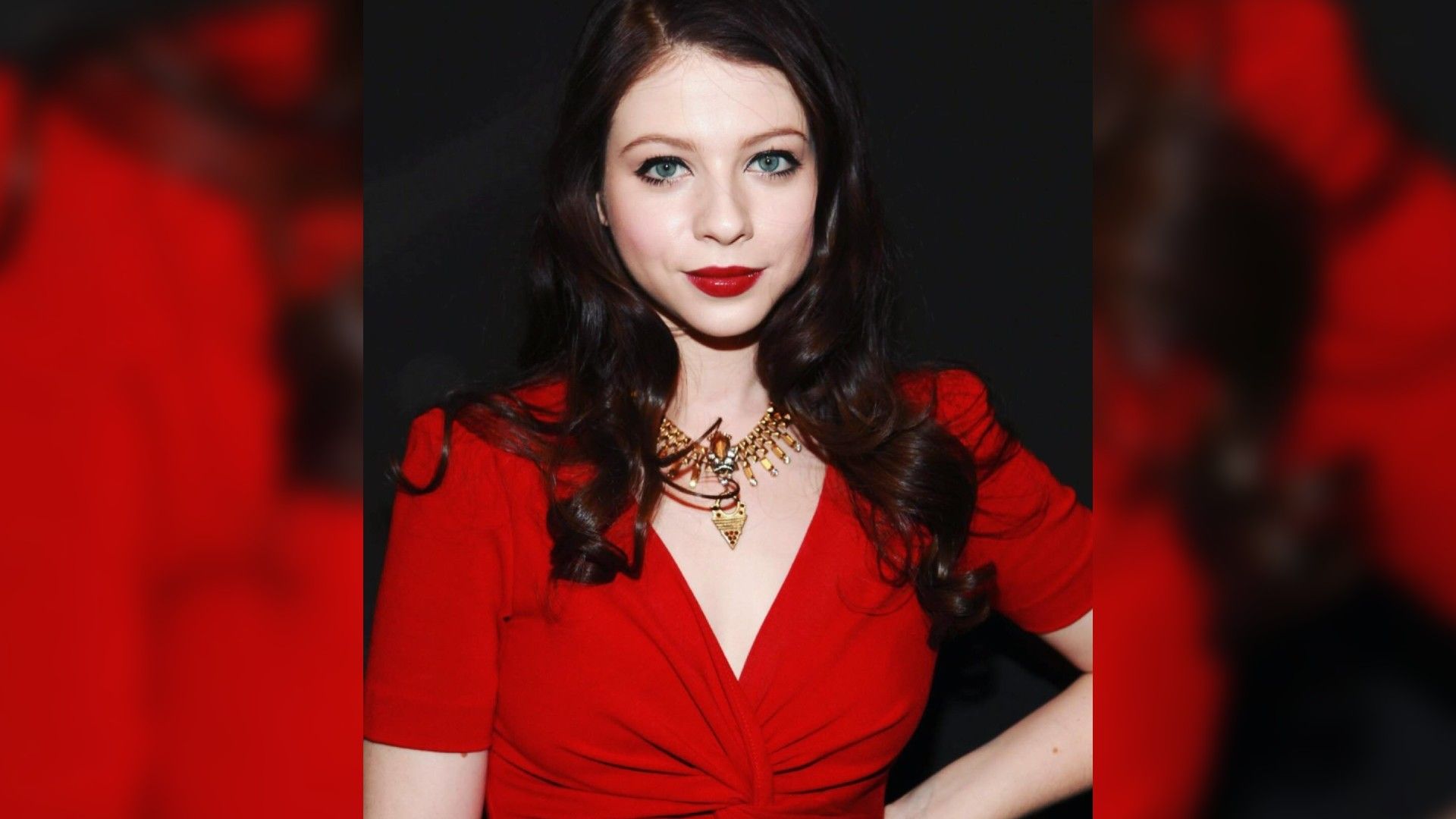 Attrice Michelle Trachtenberg con un vestito rosso e un trucco vistoso con rossetto rosso che si abbina al colore del vestito