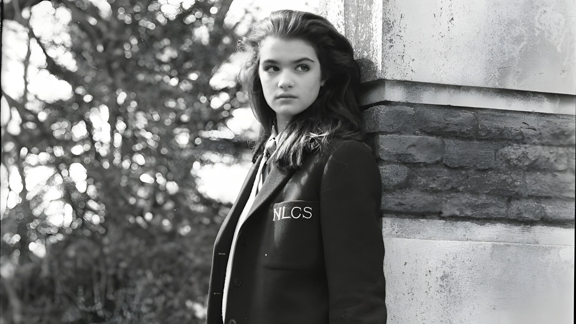 Foto in bianco e nero di una giovane ragazza vestita con l'uniforme scolastica
