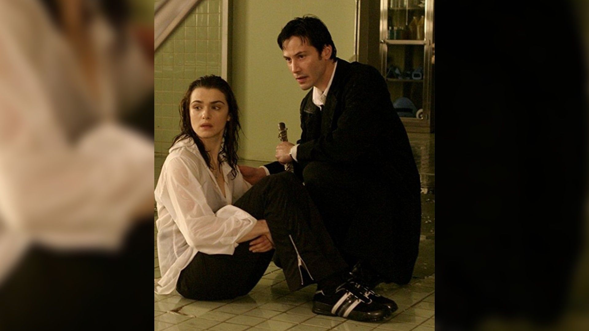 Rachel Weisz e Keanu Reeves seduti per terra uno accanto all'altro