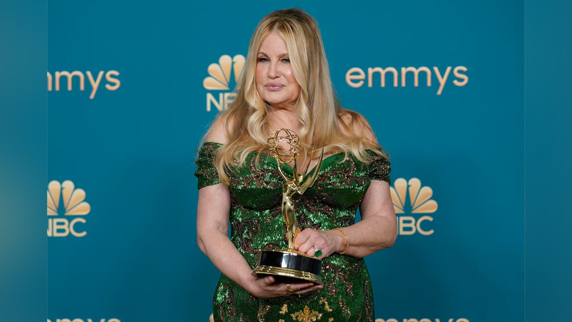 L'attrice Jennifer Coolidge in un abito verde scintillante con in mano una statuetta Emmy