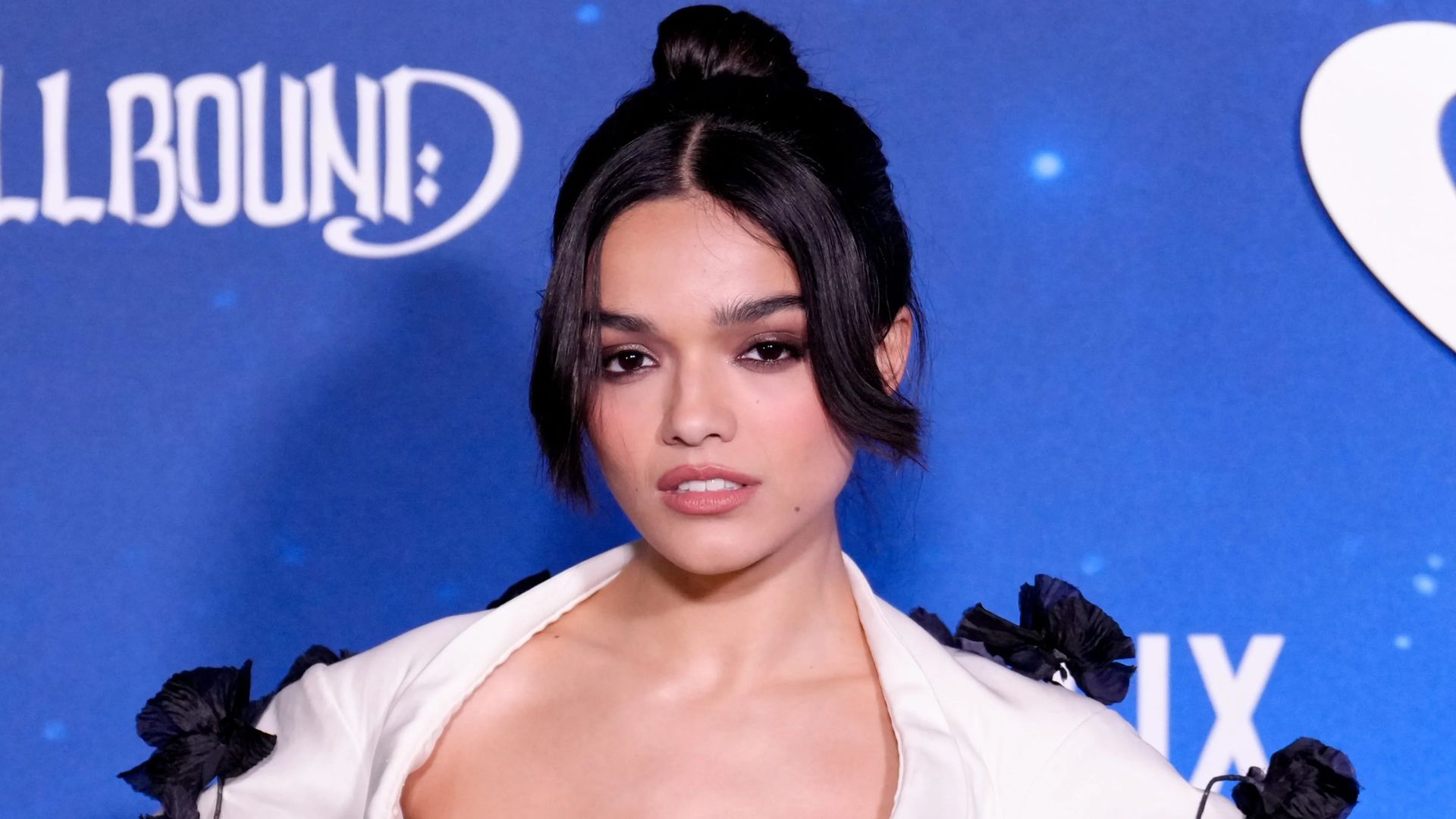 Attrice Rachel Zegler in un abito bianco su sfondo blu