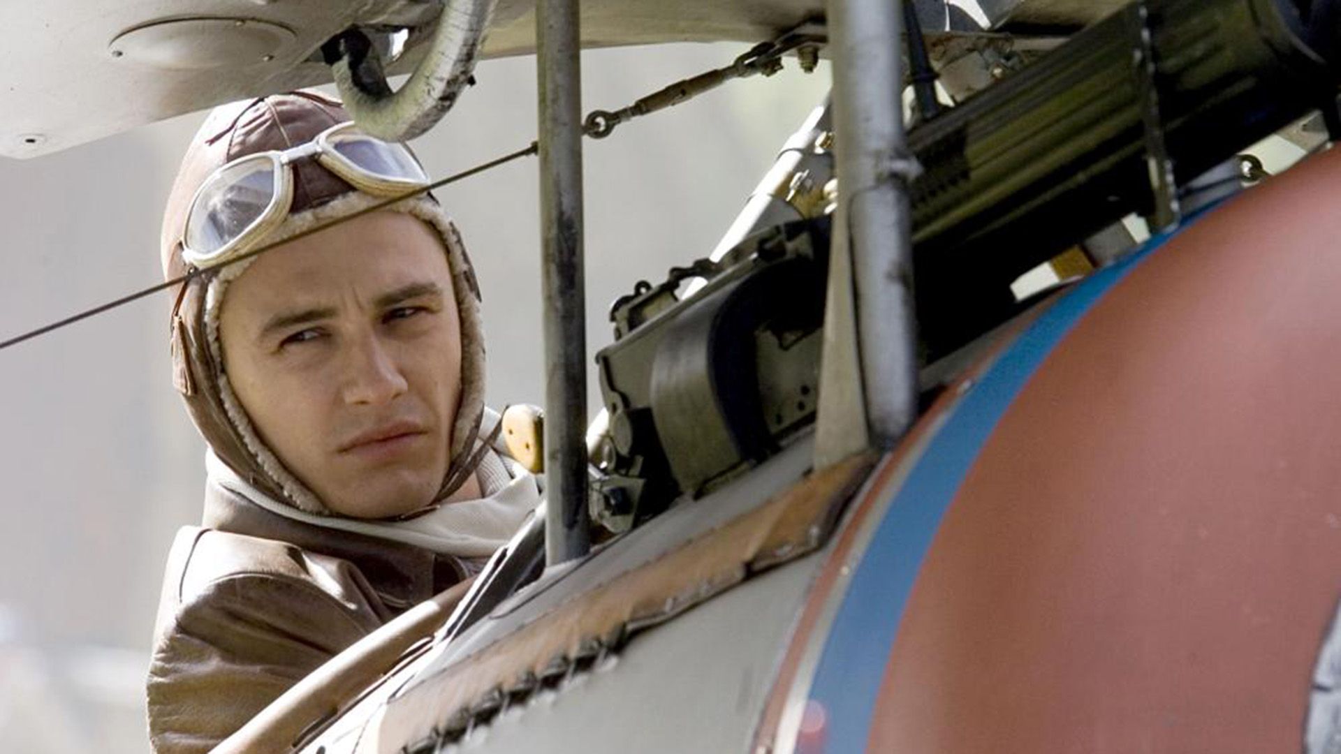 James Franco in a World War I pilot's uniform next to a military aircraft