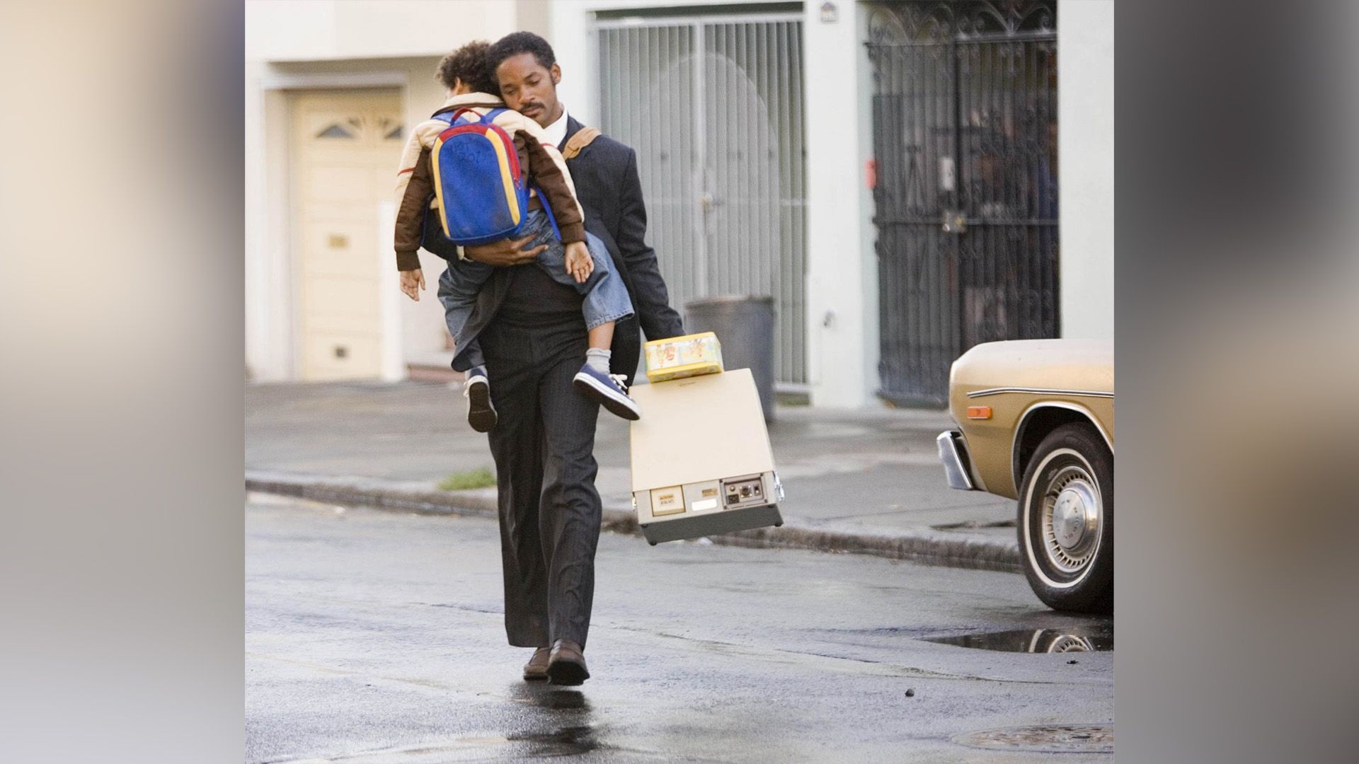 Will Smith cammina lungo la strada tenendo stretto il suo piccolo figlio