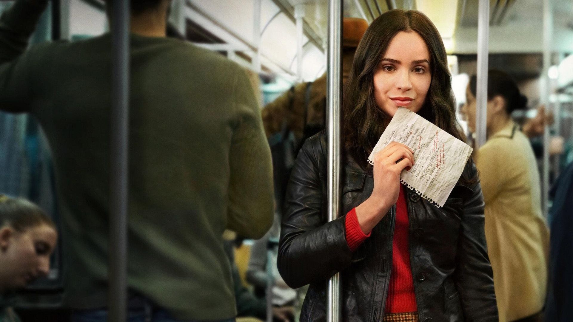 Sofia Carson stands in the subway car holding a list in her hand