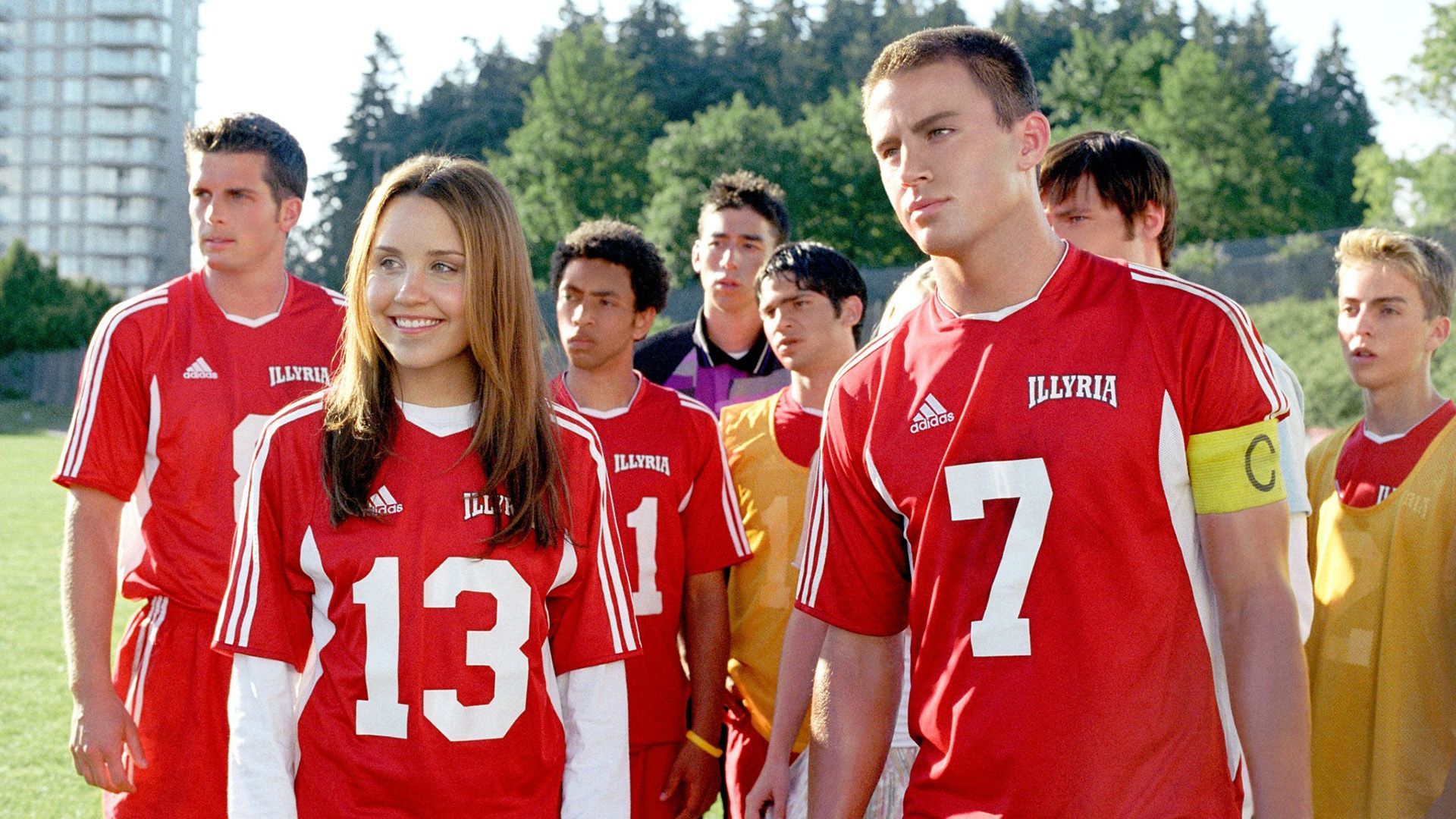 Amanda Bynes e Channing Tatum in magliette sportive rosse circondati da altri giovani