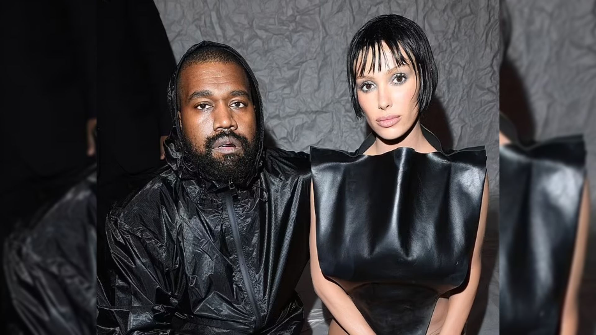 Il rapper Kanye West e sua moglie Bianca Censori posano in abiti neri contro una parete bianca