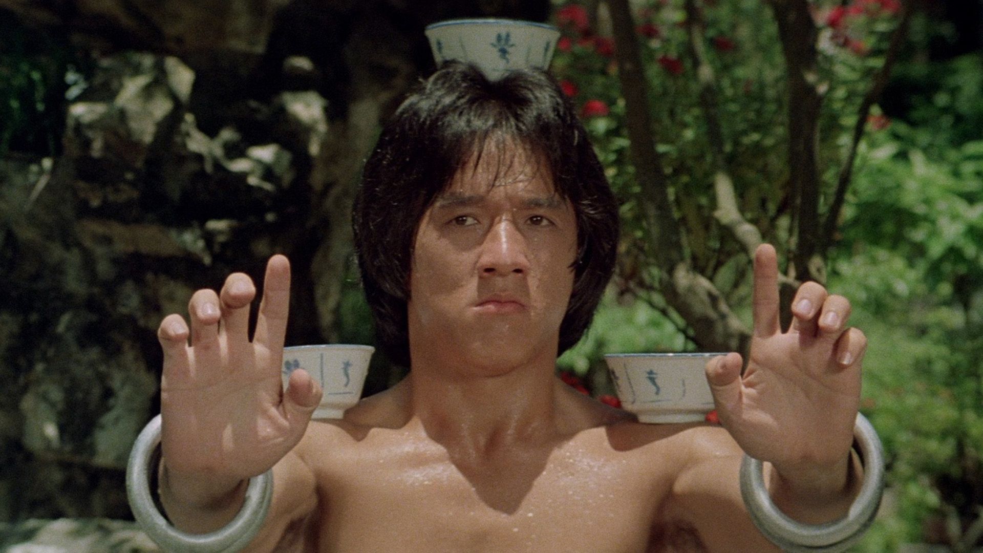 Il giovane Jackie Chan bilancia ciotole sulla testa e sulle spalle in una scena da 'Drunken Master'