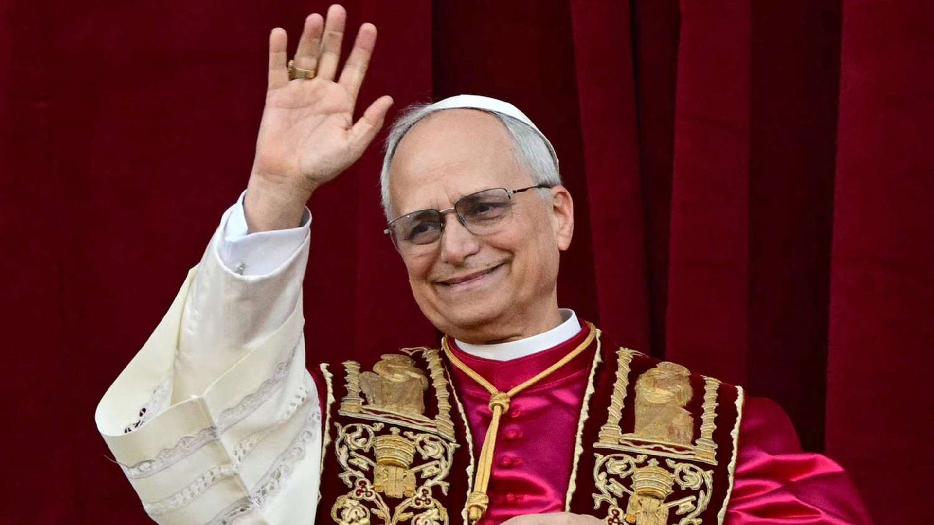 Papa Leone XIV (Robert Francis Prevost), vestito di rosso, saluta con la mano