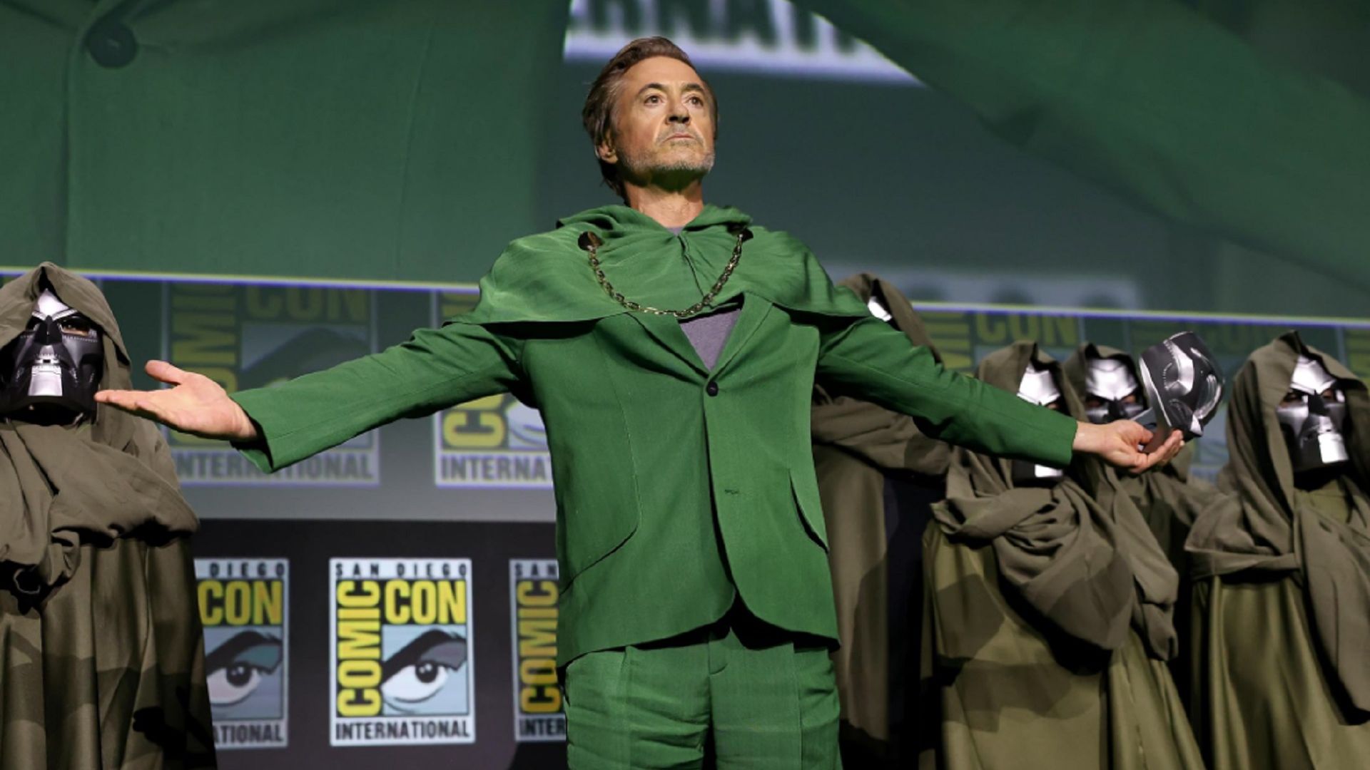 Robert Downey Jr. in abito verde sul palco, braccia aperte