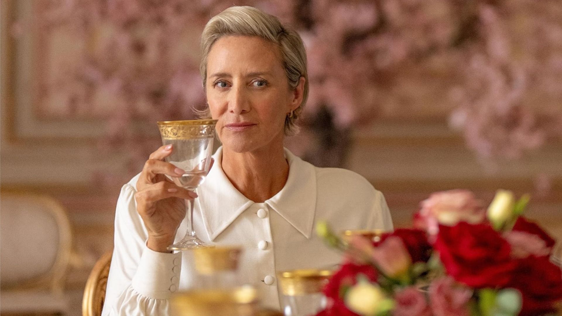 Attrice Janet McTeer seduta in una camicetta bianca con un bicchiere in mano