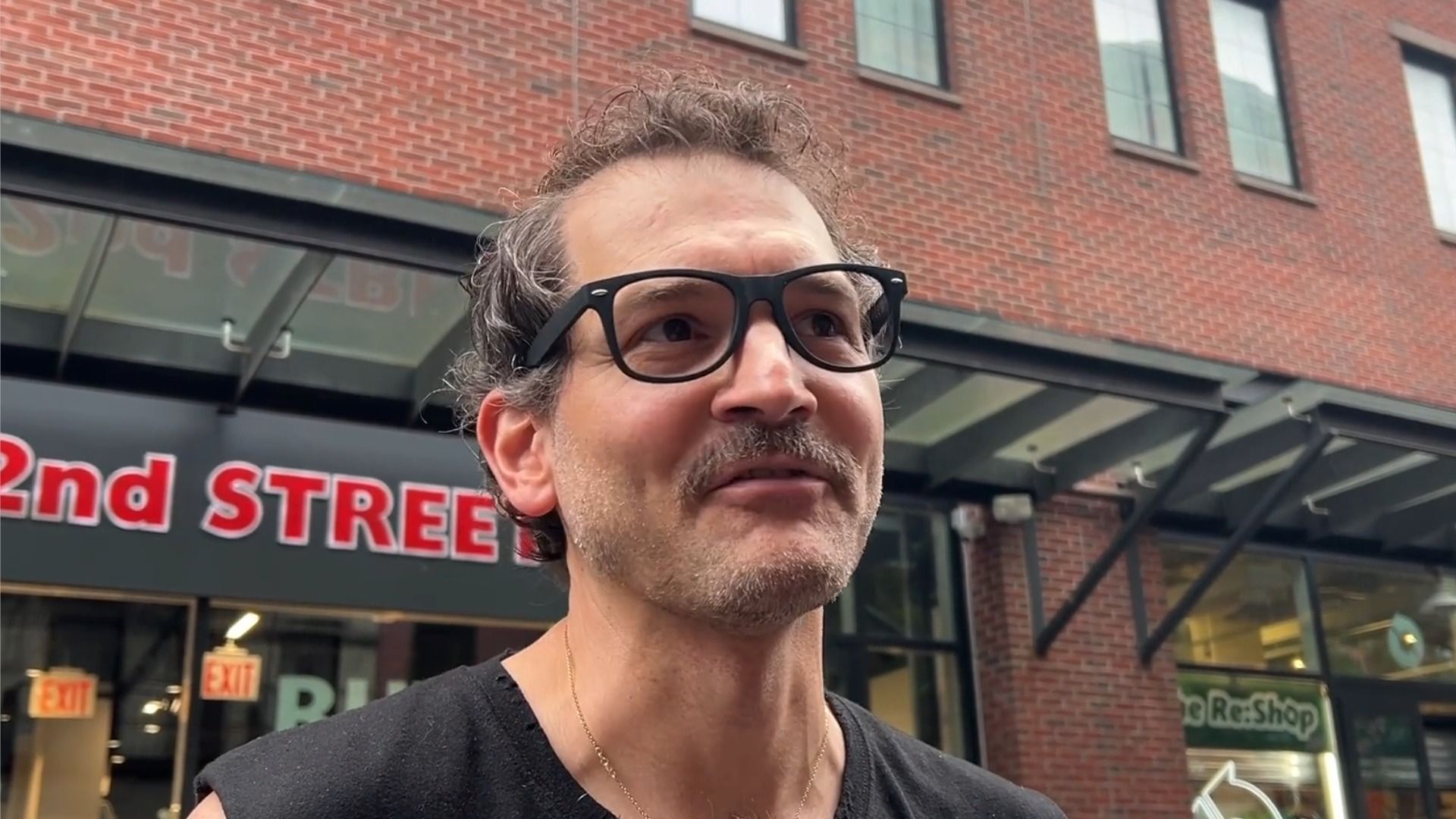 George Guntas, tecnico delle luci di The Daily Show, in canottiera nera e occhiali