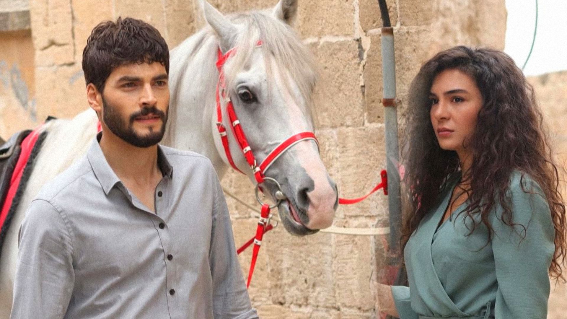 Un uomo in una camicia e una ragazza in un vestito sono in piedi accanto a un cavallo bianco