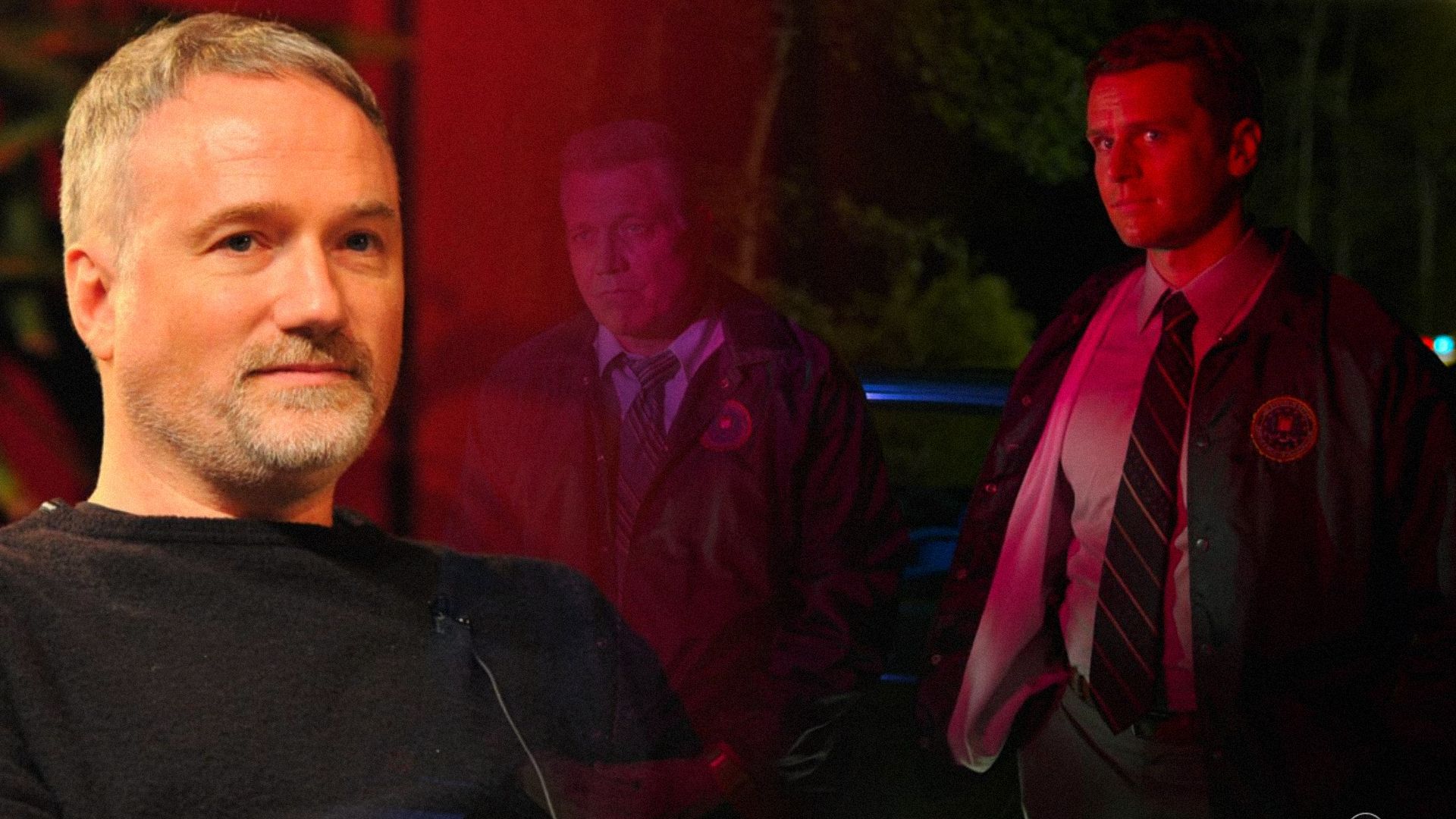 Il regista David Fincher in giacca nera e due uomini in uniforme da poliziotto