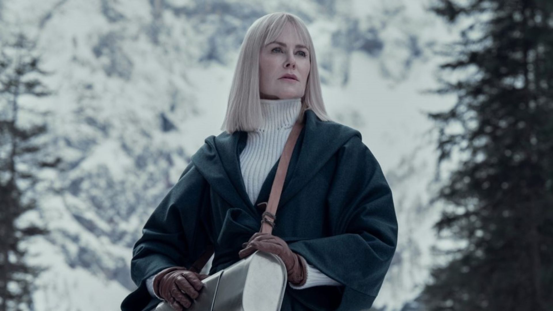 Nicole Kidman con i capelli bianchi lisci, un cappotto di pelle nero e un maglione bianco