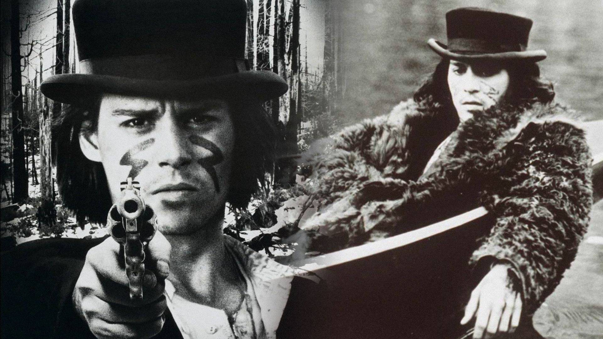 L'attore Johnny Depp con cappello nero e pistola in mano guarda verso la camera