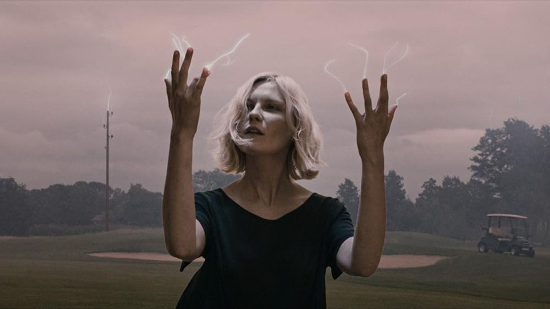 L'attrice Kirsten Dunst guarda le sue dita da cui emanano piccoli fulmini