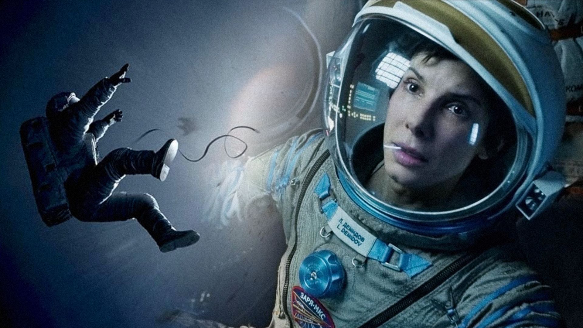 L'attrice Sandra Bullock in tuta spaziale guarda di lato con un'espressione seria sul viso