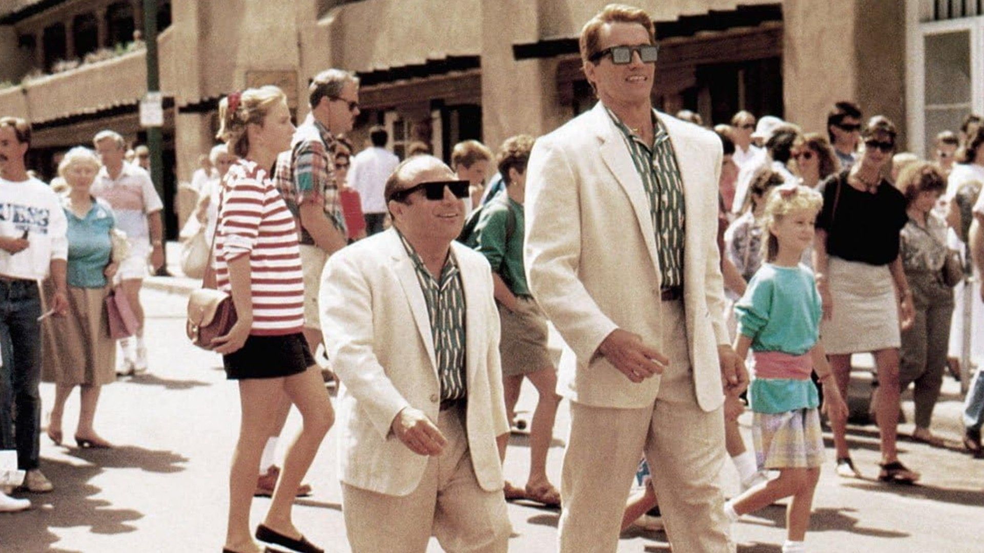 Danny DeVito e Arnold Schwarzenegger in abiti bianchi che camminano fianco a fianco