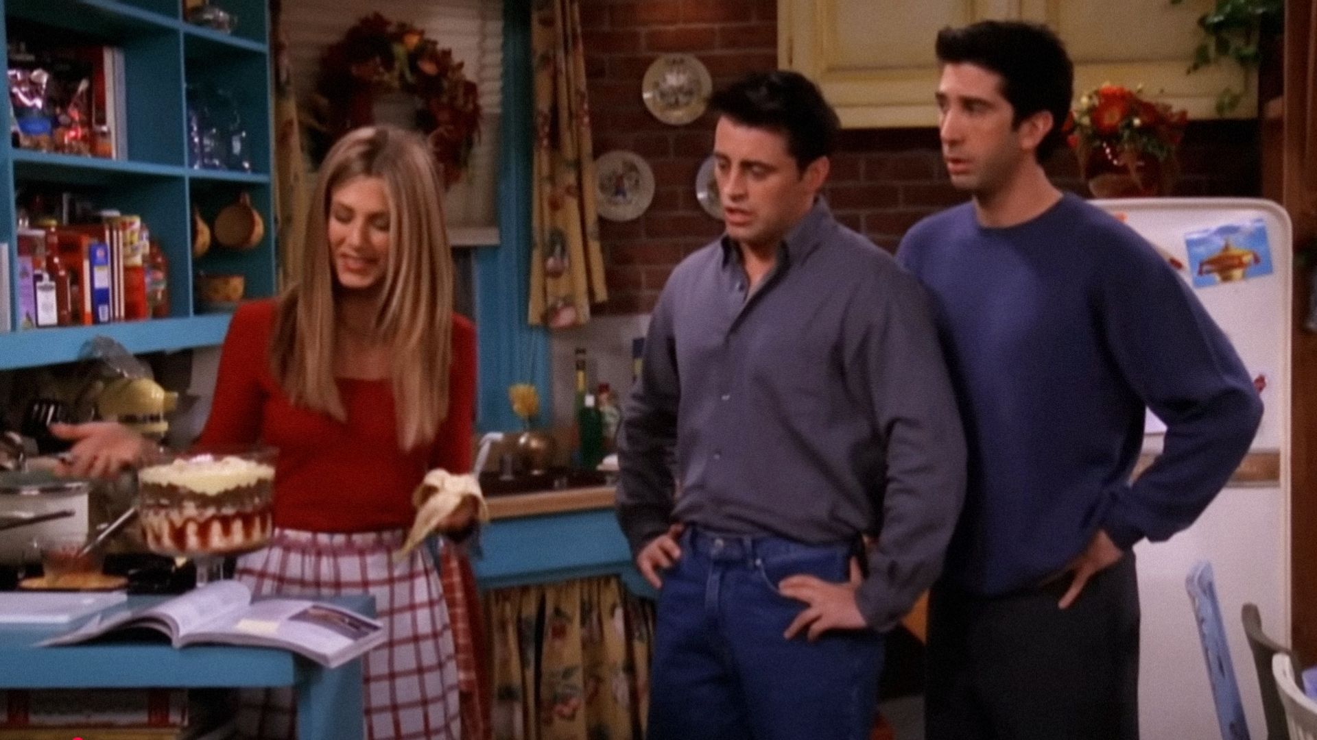 Gli attori Jennifer Aniston, David Schwimmer e Matt LeBlanc che guardano una pirofila trasparente con lo sformato
