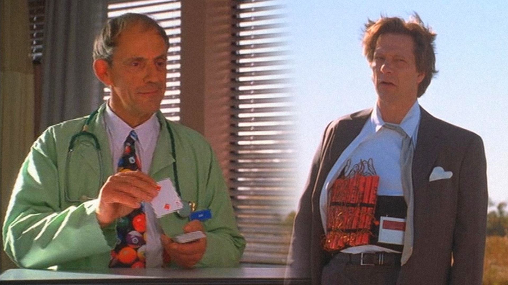 L'attore Christopher Lloyd in vestaglia con carte in mano, l'attore Chris Cooper in giacca con esplosivi