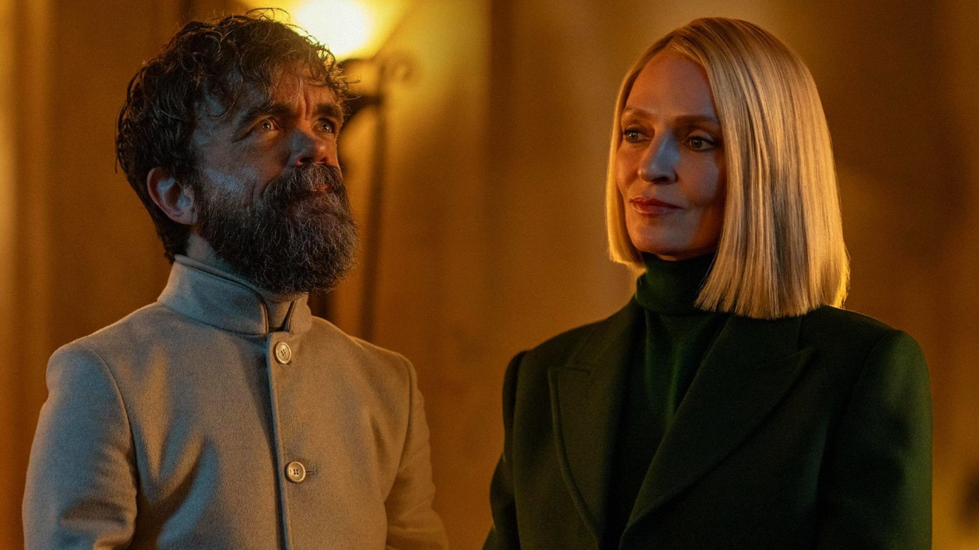 L'attore Peter Dinklage con i capelli corti e vestiti bianchi, l'attrice Uma Thurman in un blazer verde