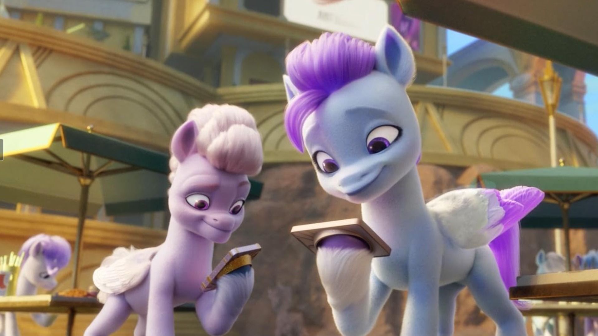 Un pony con la criniera rosa e un pony con la criniera viola che tengono i telefoni con gli zoccoli