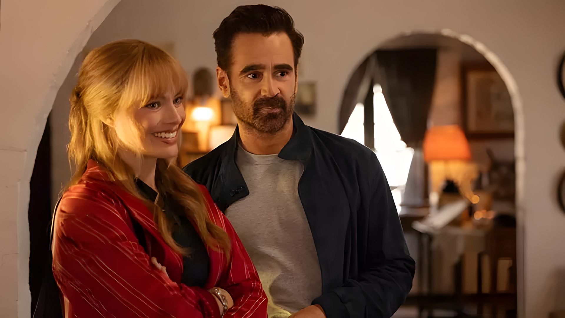 Margot Robbie e Colin Farrell in piedi uno accanto all'altro in una stanza accogliente con illuminazione calda e soffusa