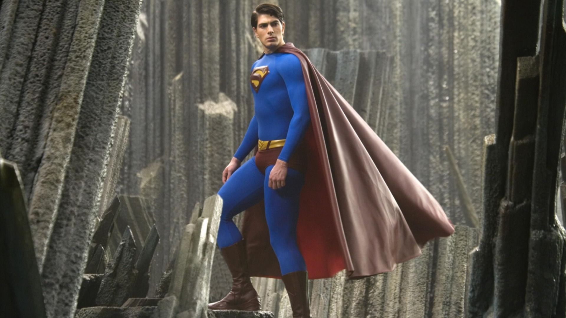 L'attore Brandon Routh in costume da supereroe blu e rosso con la lettera S sul petto sale le scale