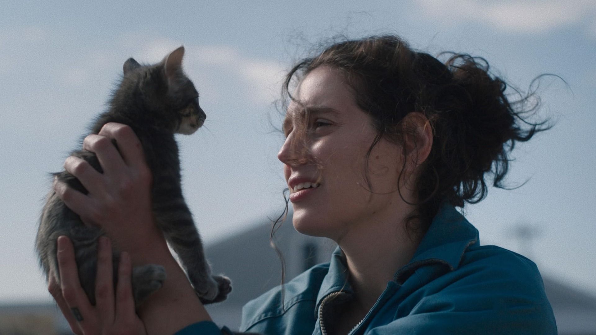 Ragazza in giacca blu che tiene un gattino grigio