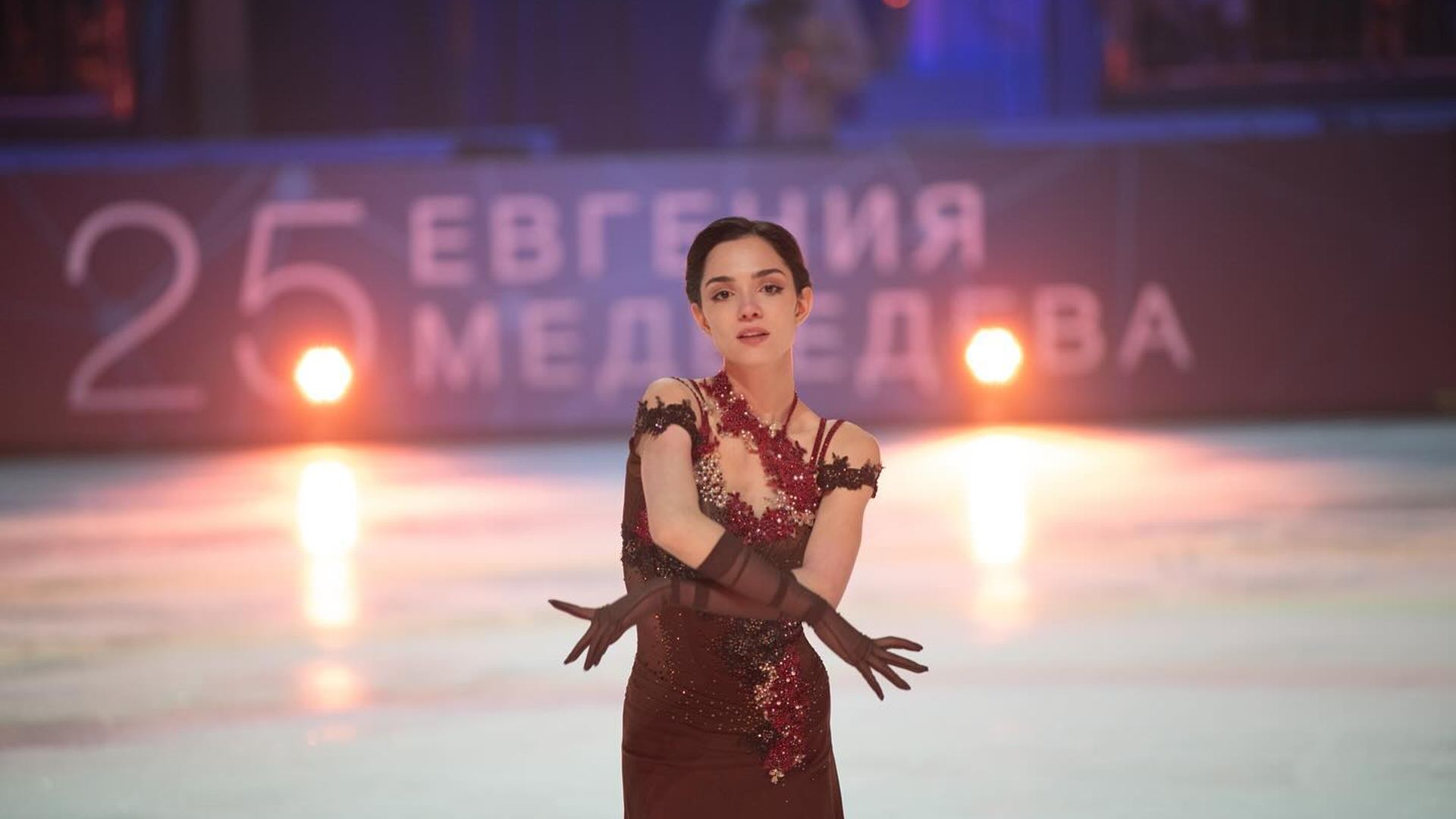 Evgenija Medvedeva si esibisce sul ghiaccio in un costume bordeaux durante lo spettacolo
