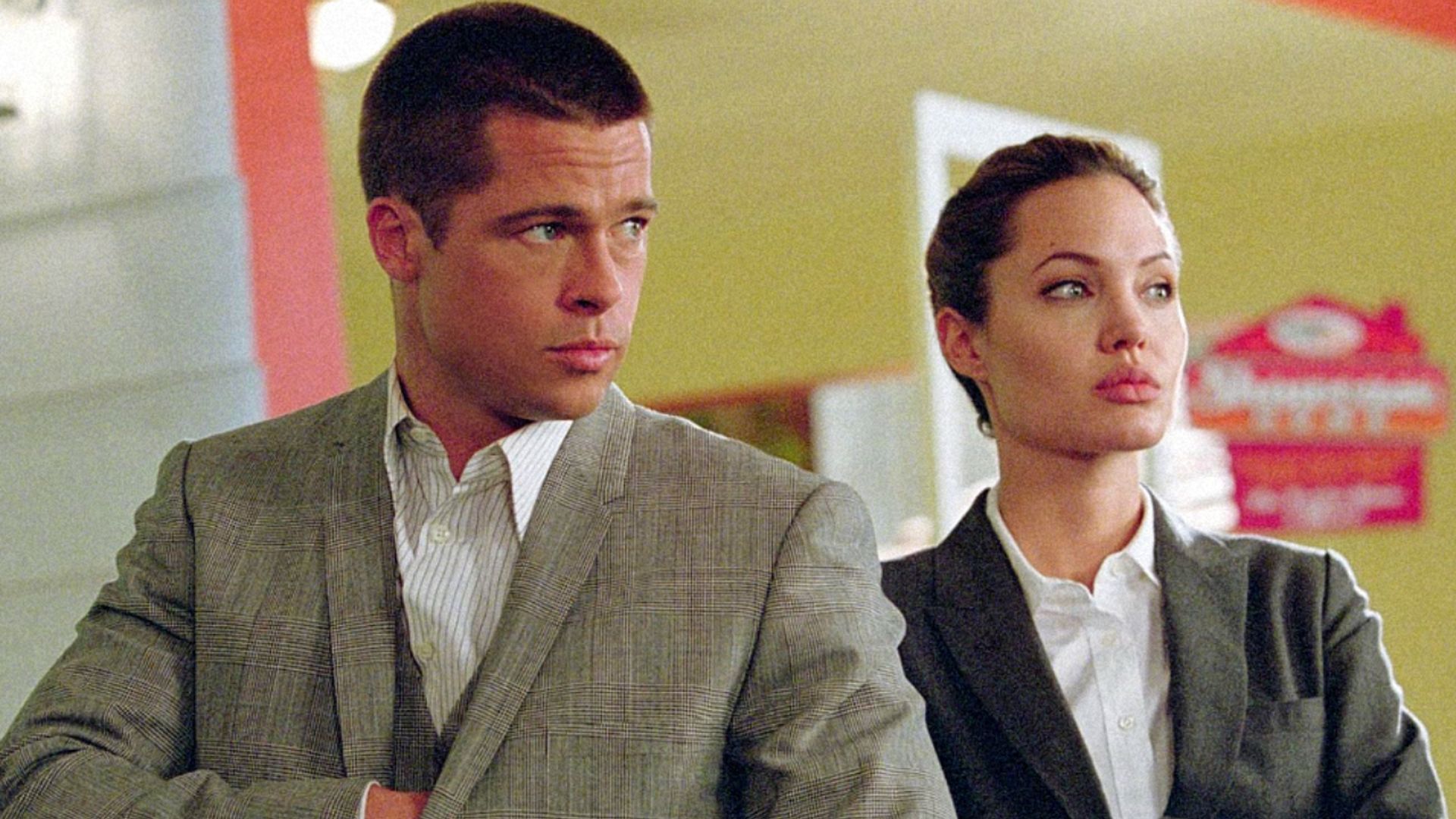 L'attore Brad Pitt in blazer grigio con taglio di capelli corto, l'attrice Angelina Jolie in blazer grigio e camicia bianca
